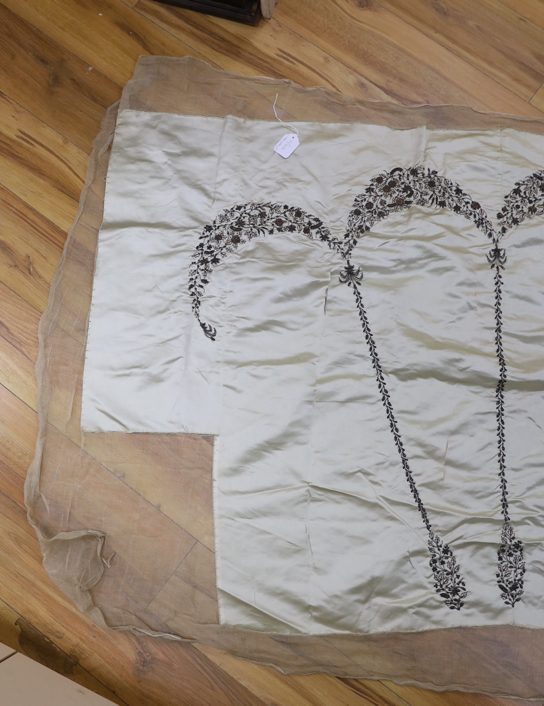 A 19th century pale green silk satin ladies dress skirt, embroidered into wide swags of silver metallic and pink threads